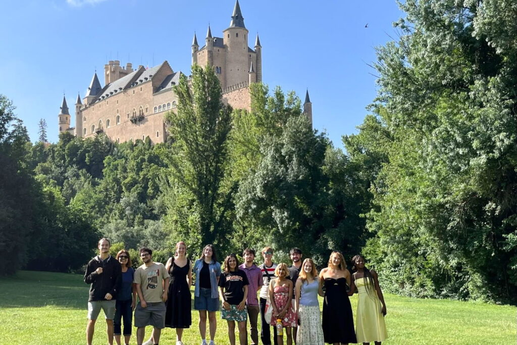 Thirteen students outside of the Alcazar of Segovia, a medieval fortress in Spain.
