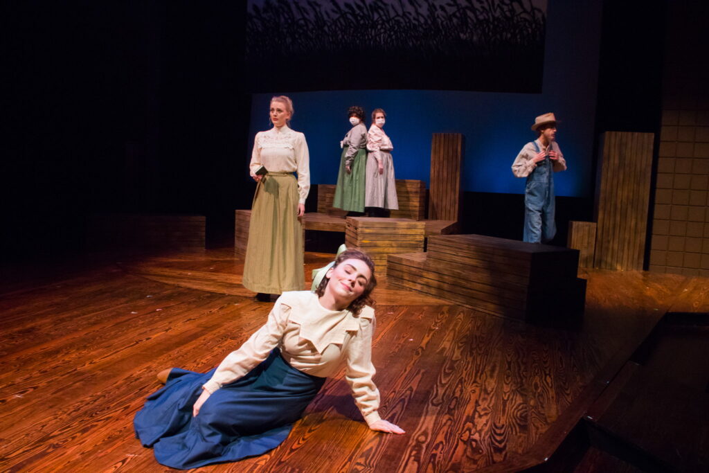 Students performing a play on stage inside the Cabe Theater.