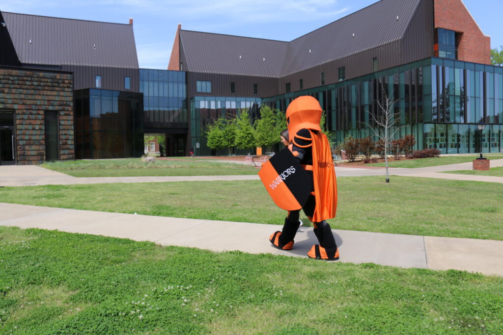 Warriors mascot walking on the sidewalk in the Miller Quad.
