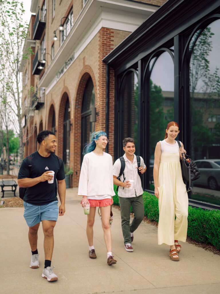 A group of students walking down a sidewalk in Conway.