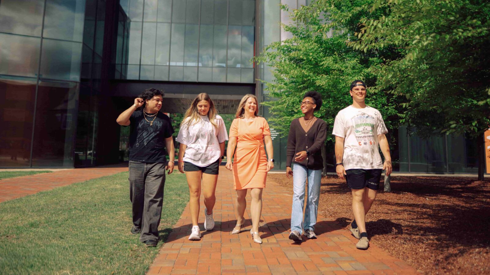 President Karen Petersen and four students walk through Hendrix campus.