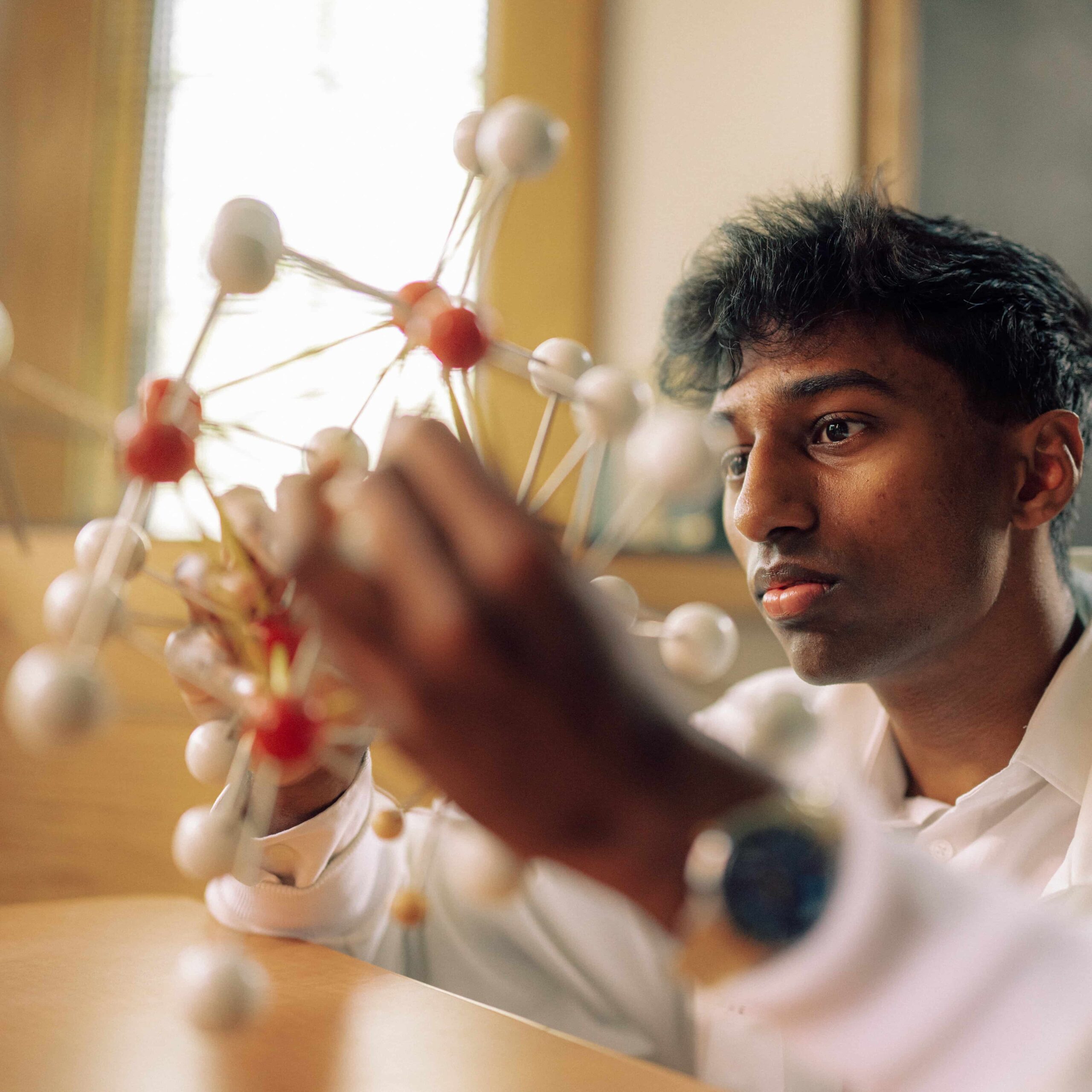A student observes a model of a molecule.