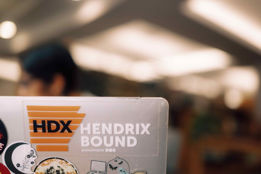 The back of a laptop computer that is covered in stickers, including a Hendrix Bound sticker.