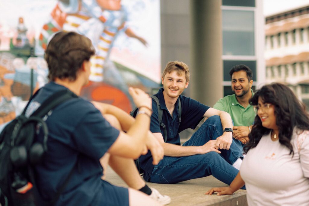 A group of four students having a conversation in Conway, Arkansas.