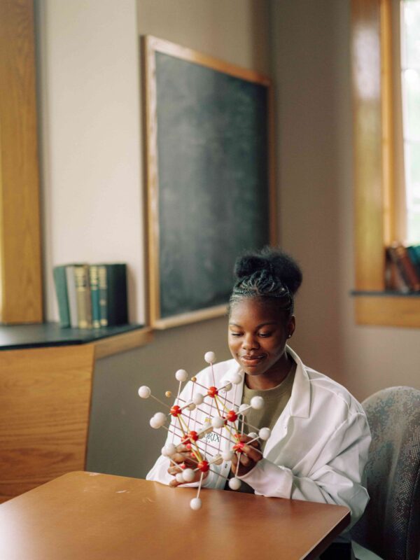 A student looking at a 3D model of a molecule.