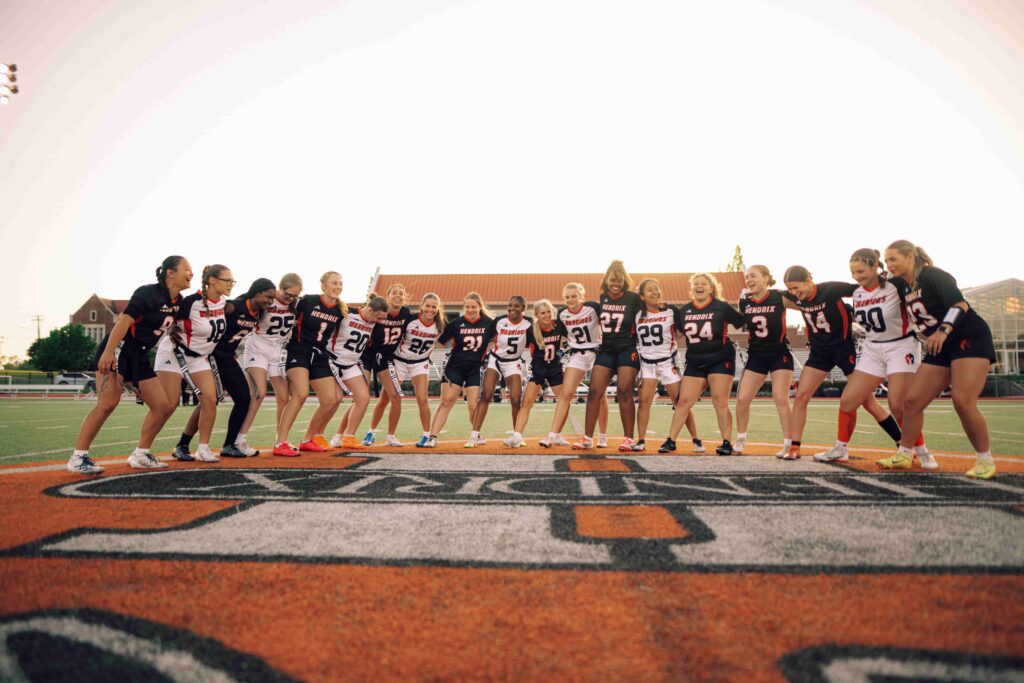 The Hendrix women's flag football team, locked in arms while preparing for a game.