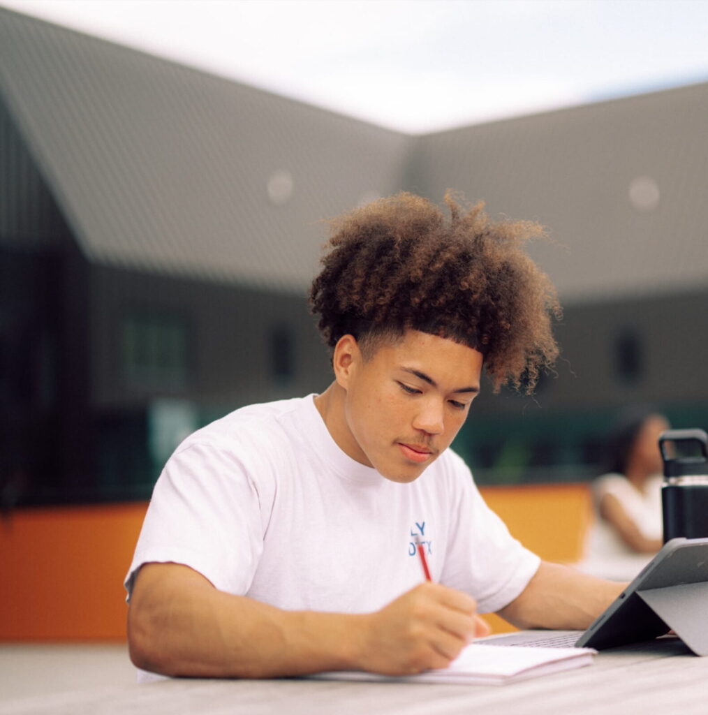 A male Hendrix College student doing homework at a table.