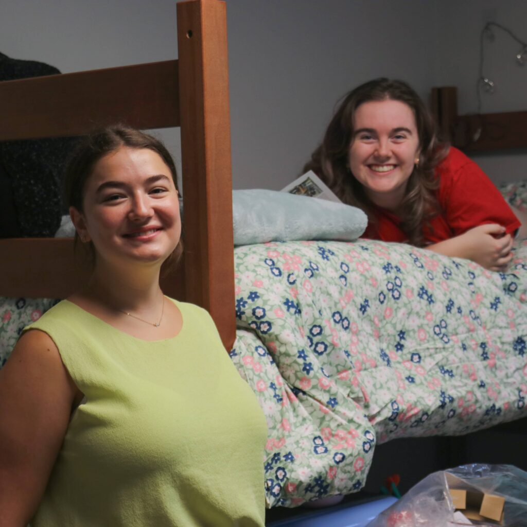 Two students getting settled into their dorm room.