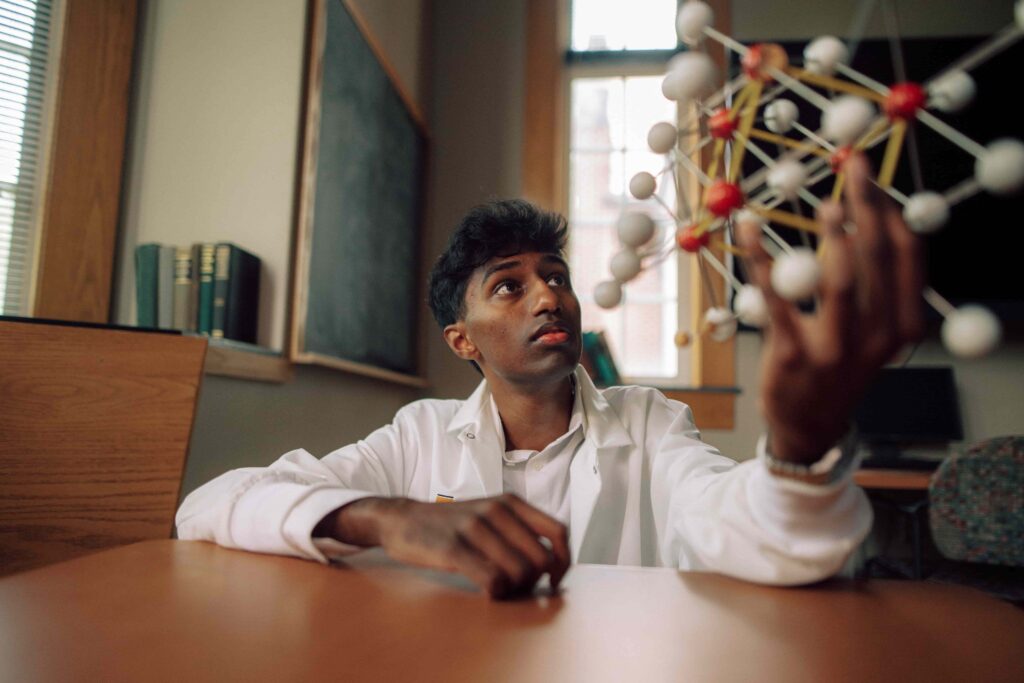 A student holding a molecular model.
