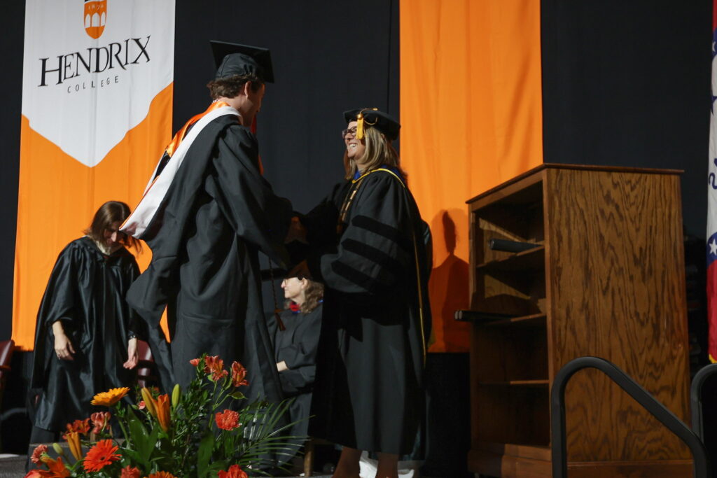 President Petersen shakes hands with a student at the Commencement ceremony.