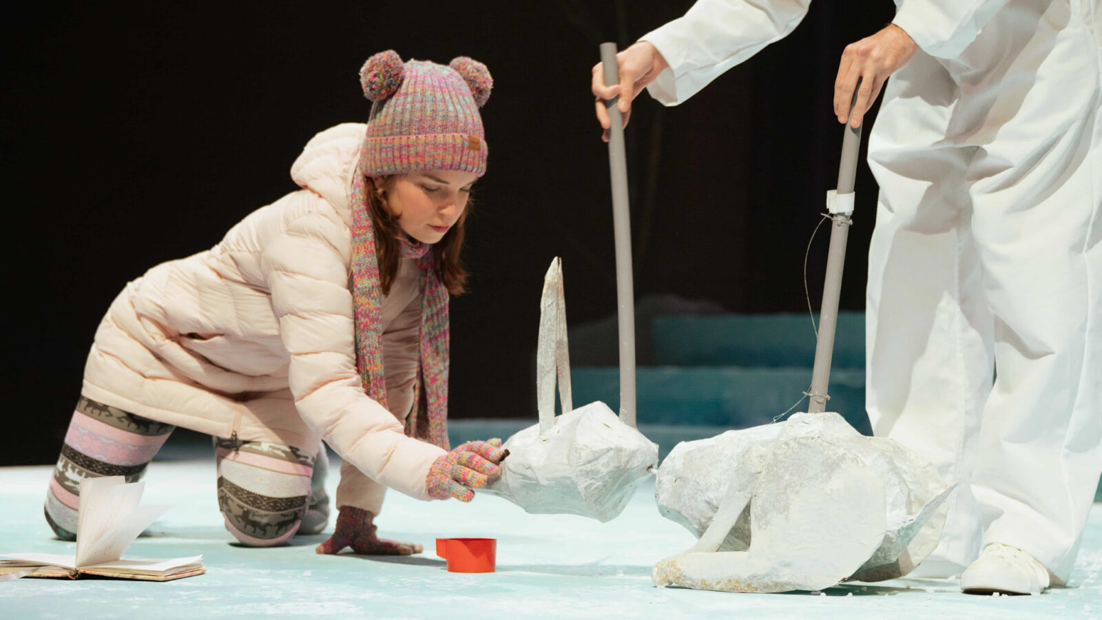 Hendrix College theatre arts students on stage interact with paper mache animal props during a theater production rehearsal.