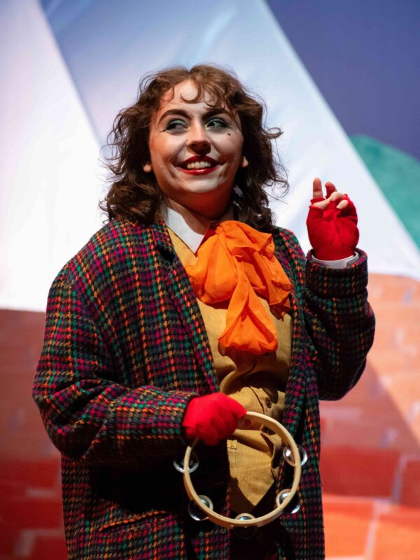 A student in a colorful costume performing on stage.