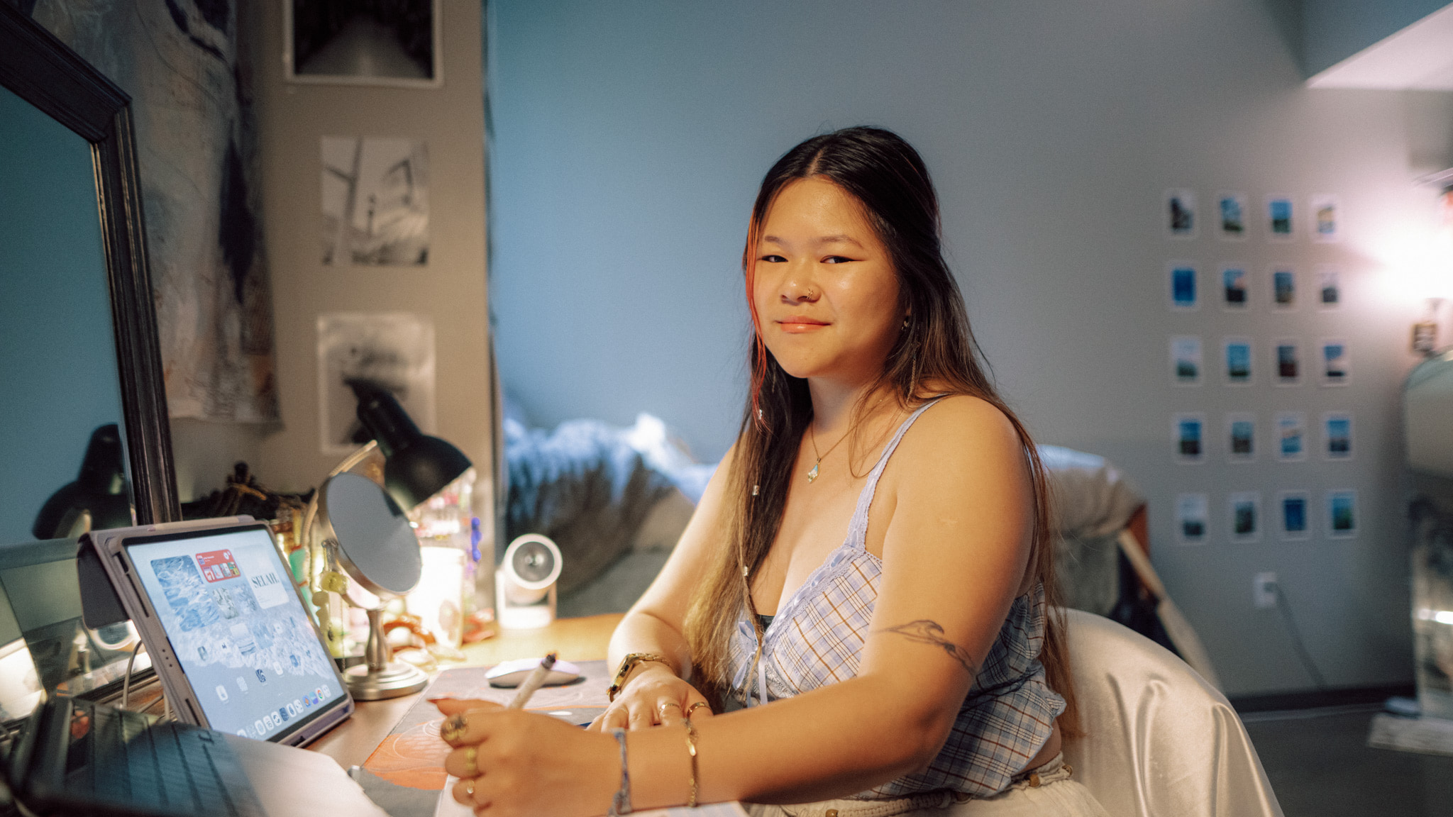 One person sits at a desk in their well-lit dorm room.