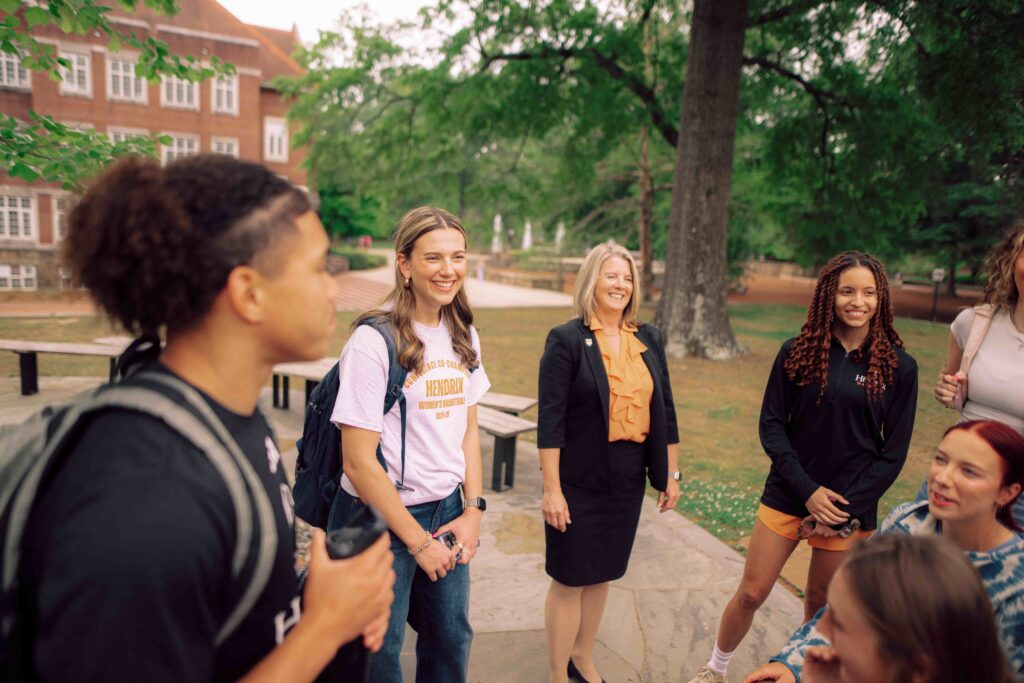 A group of people on a sidewalk on the Hendrix campus.