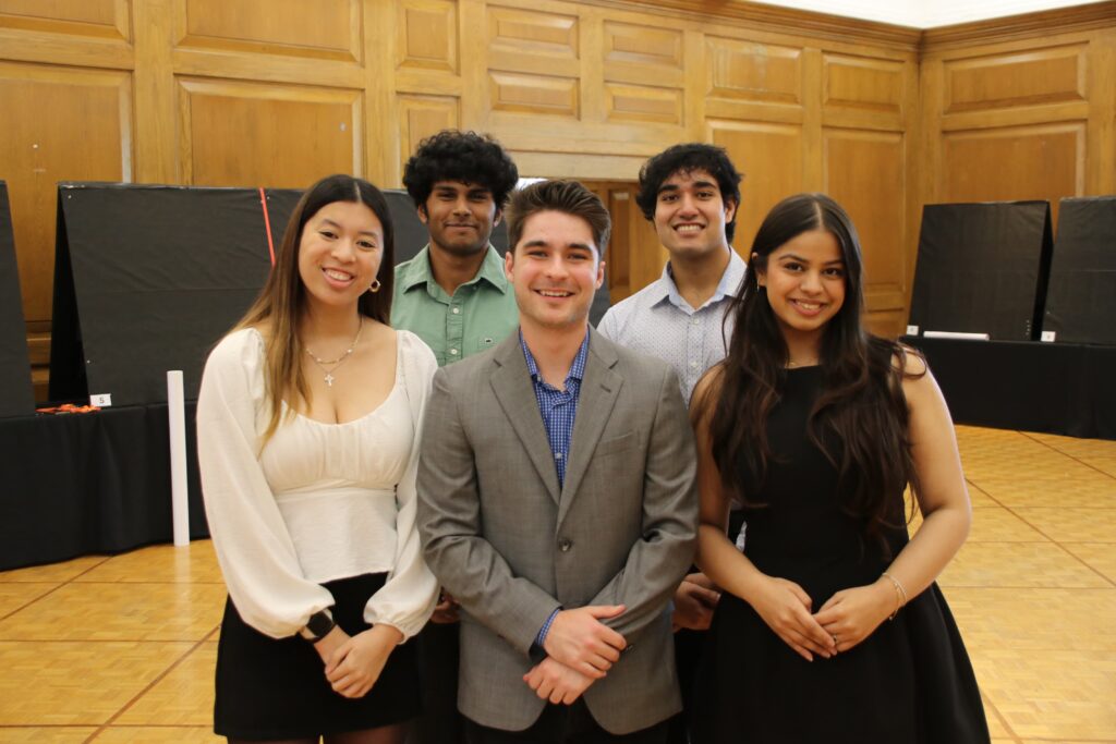 A group of five students standing together.