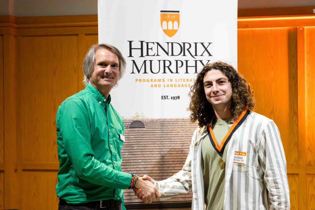 A faculty member shaking hands with a student.