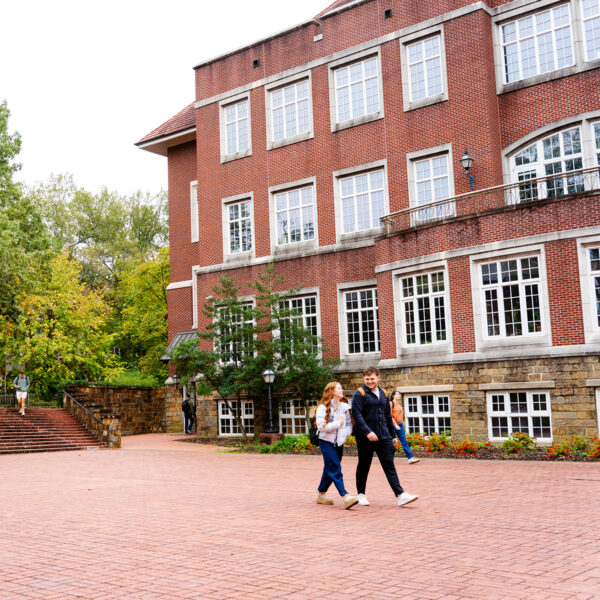 Four Hendrix students walk outside in front of the Donald W. Reynolds Center for Life Sciences building on a sunny day.