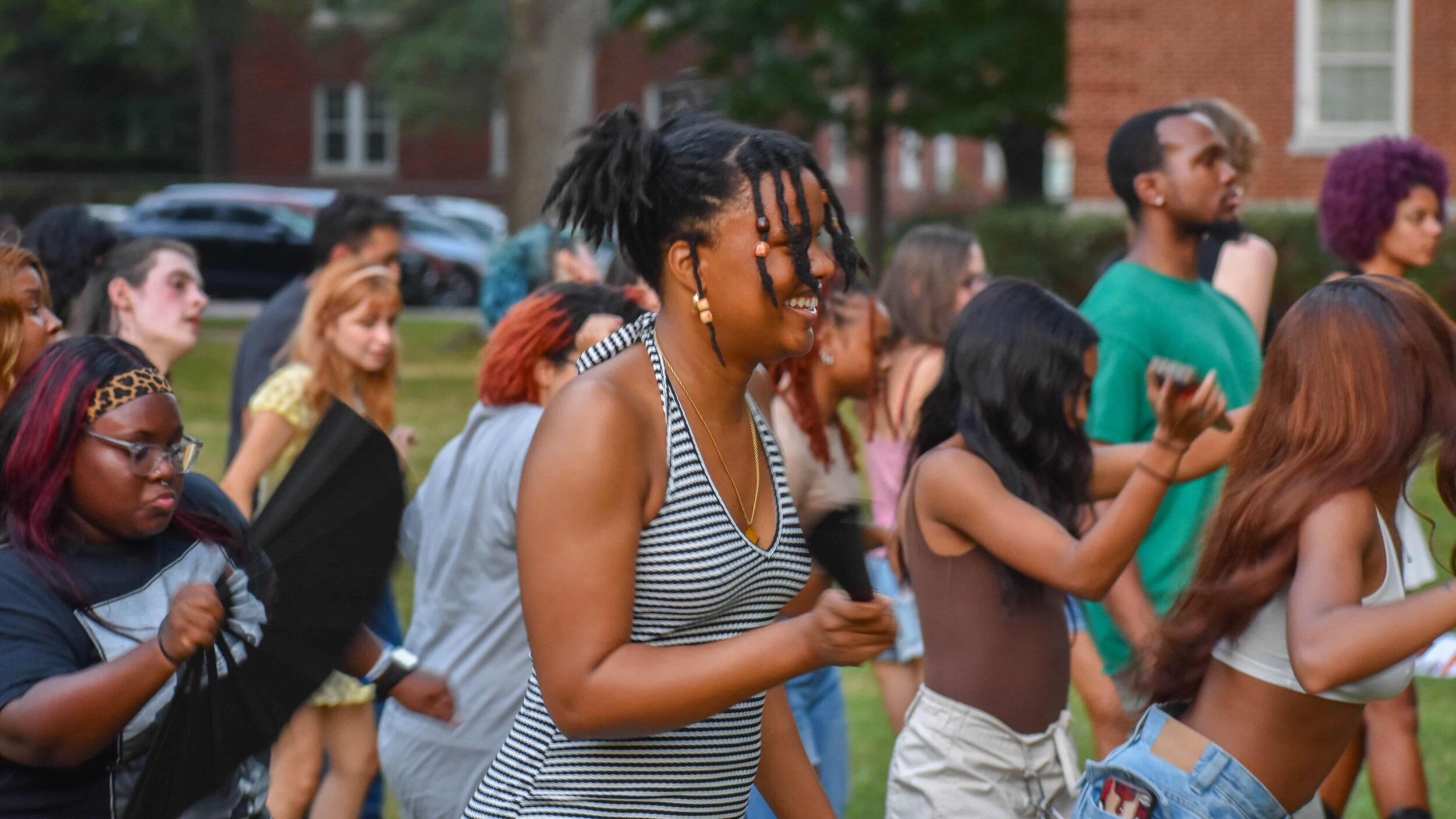 A group of students dance together outdoors.