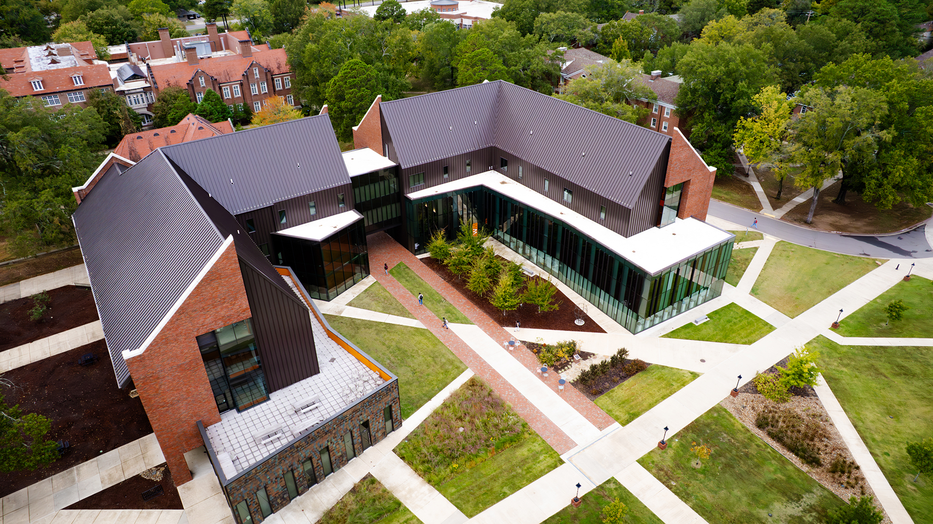 Aerial view of Hendrix’s Miller Creative Quad building with slanted roofs, glass-paneled walls, green grass, and crisscrossing sidewalks.