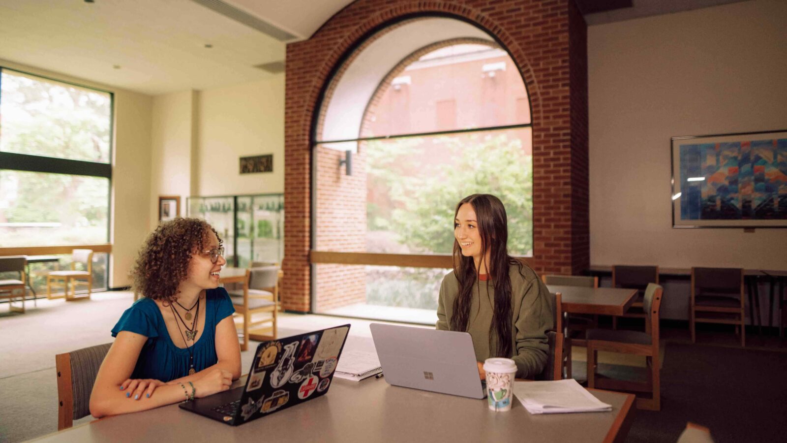 Students sit at a table in a library.