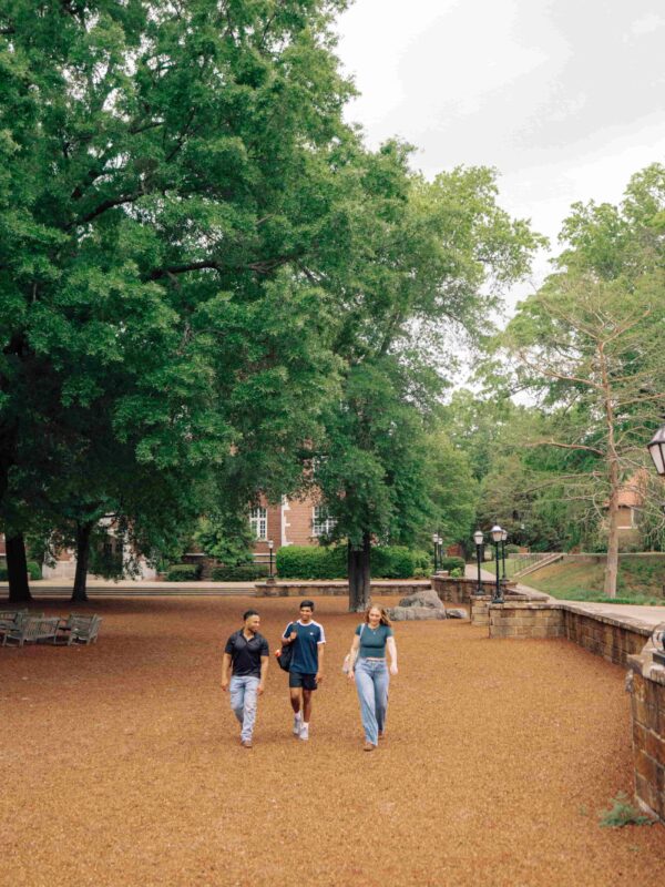 Three students walking across campus.