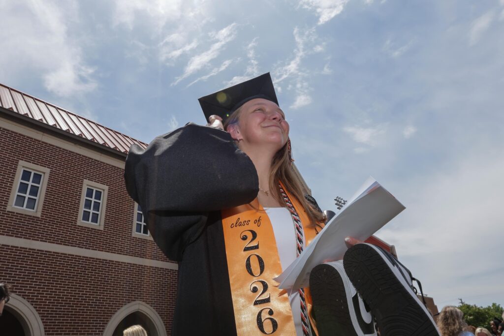 A student in regalia graduates at a commencement ceremony.