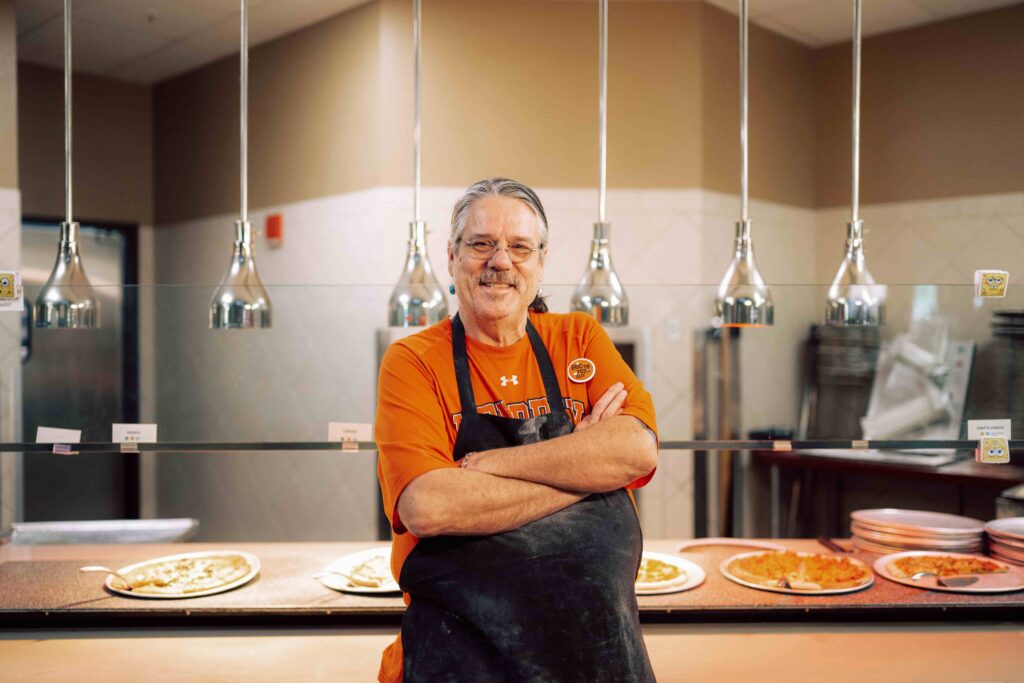 Eric the Pizza Guy stands in front of his pizzas