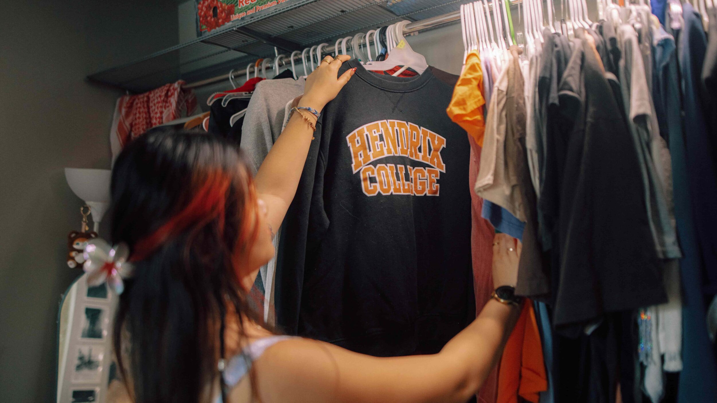 A student pulls a Hendrix College sweatshirt from their closet.
