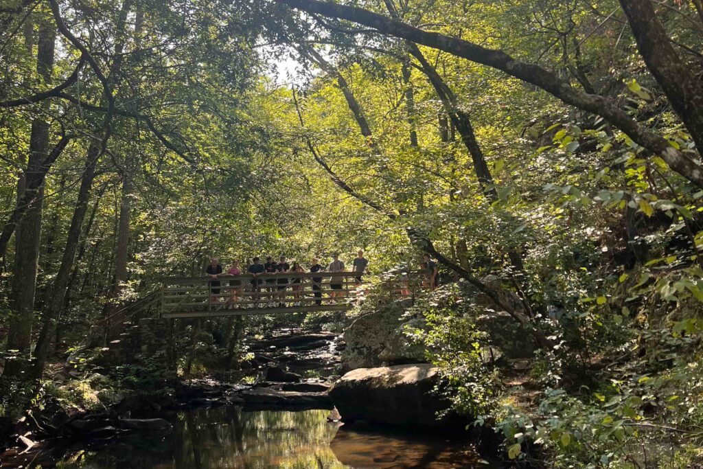 Students stand on a bridge during an outdoor Orientation Trip.