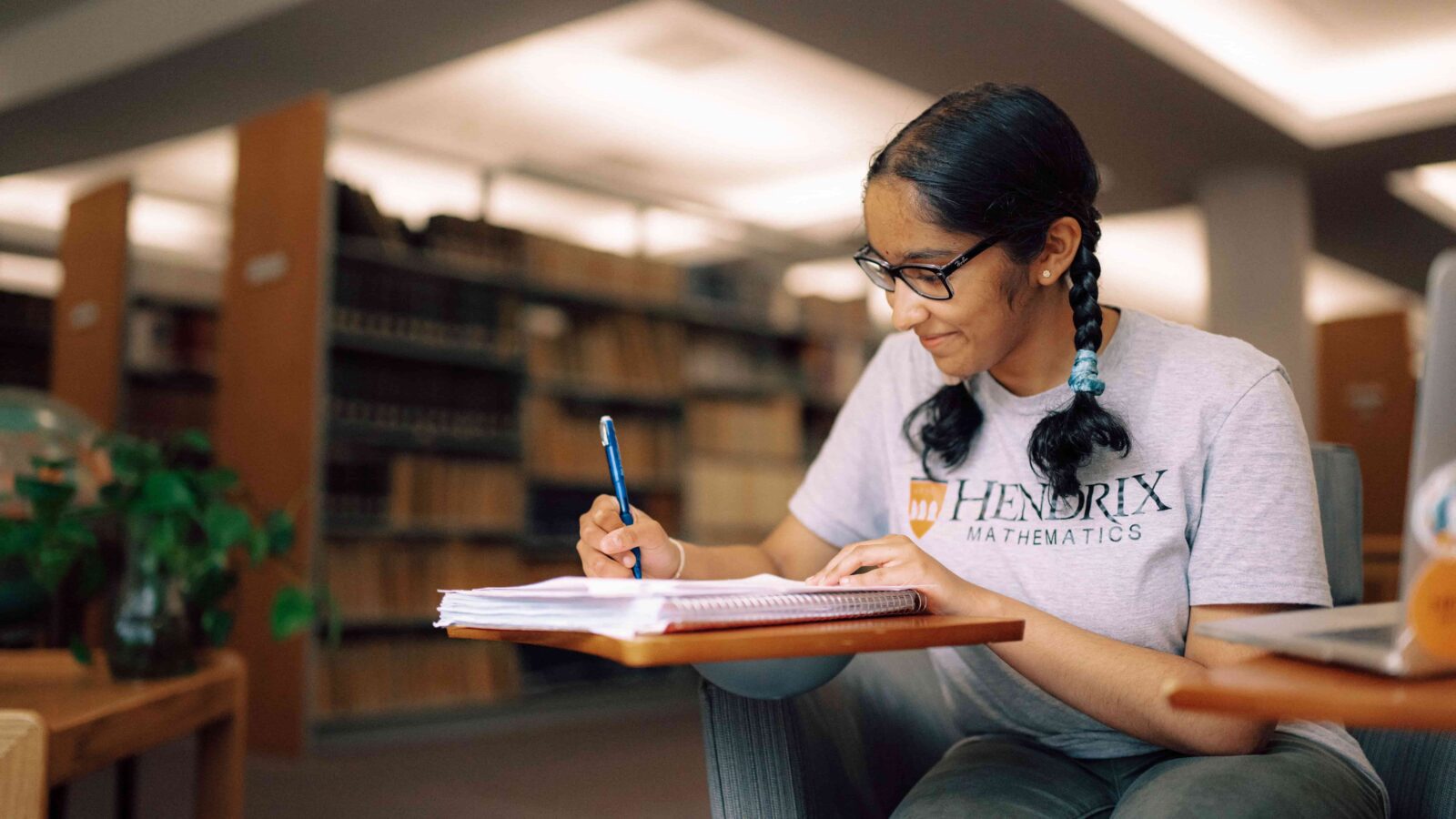 A student studies with a book in the library.