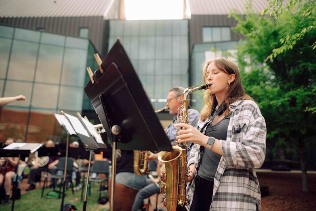 Students in the orchestra playing saxophone.