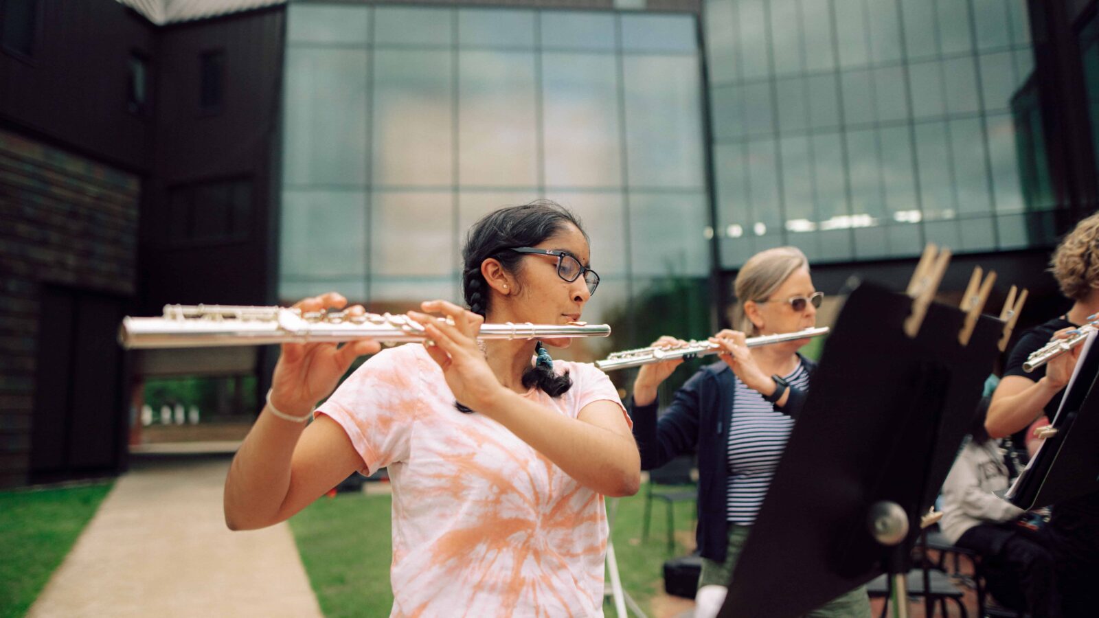 Students in the orchestra playing flute.