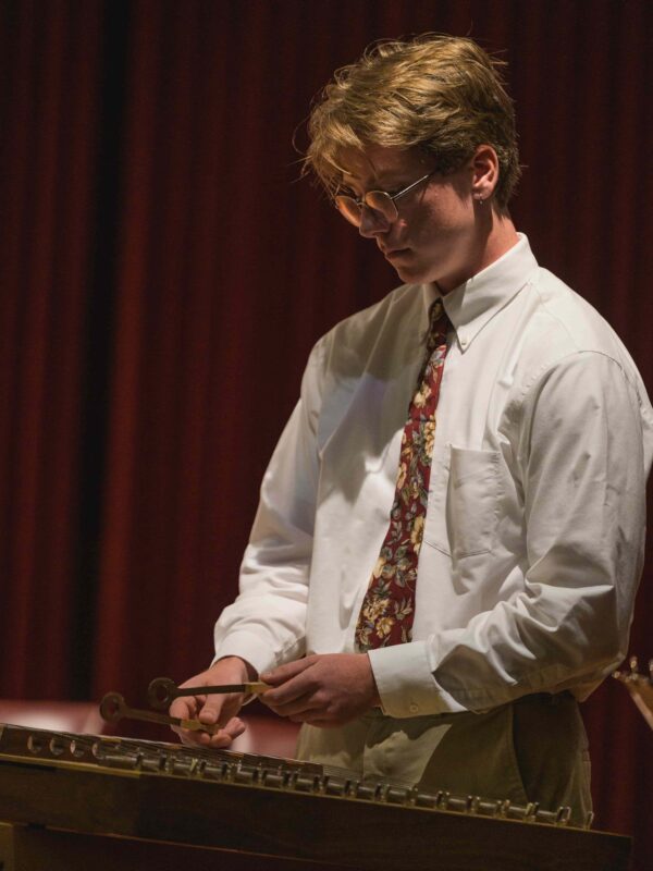A student on stage playing xylophone.