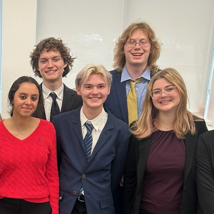 Vic Welky and others on the Mock Trial team smile for a photo